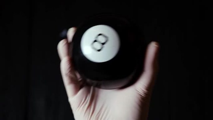 预测球数字八号手握在黑色背景上的手套中。