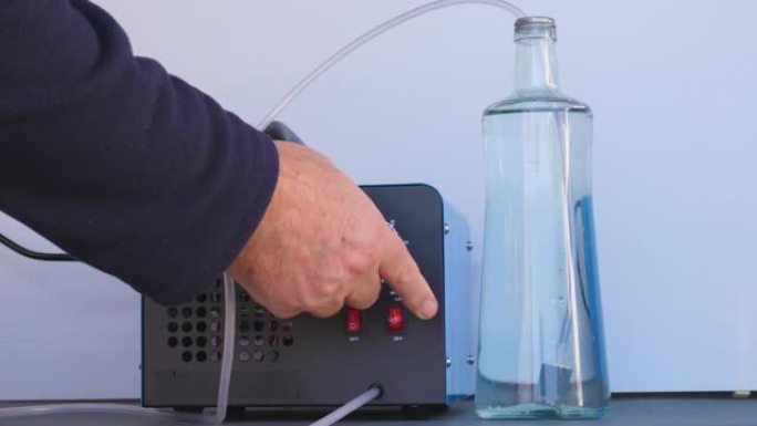 一瓶冰水用圆形臭氧化石进行臭氧化。通向氧气泵和臭氧发生器的管子