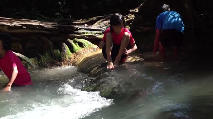 儿童在旅游暑假山上的瀑布中玩耍，亚洲快乐的儿童在大自然中旅行