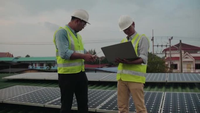 工程师在太阳能农场使用笔记本电脑和项目计划，在太阳能安装时检查面板