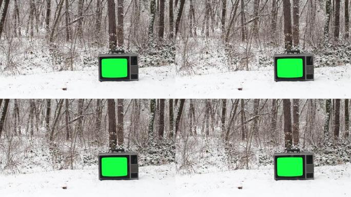 森林里下雪，地面上有绿色屏幕的老式电视