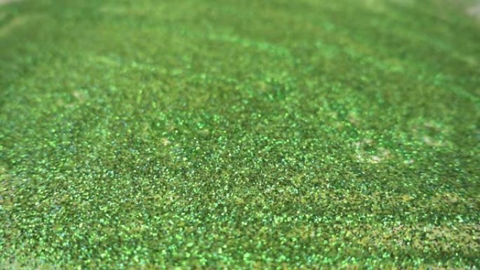 在慢动作中，液体滴落在由绿色小点组成的表面上。