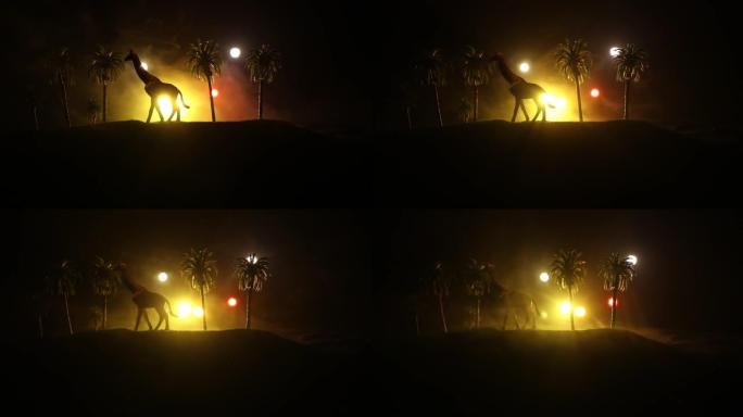 站在雾蒙蒙的夜晚的长颈鹿微型剪影。创意餐桌装饰，彩色背光带雾。选择性聚焦