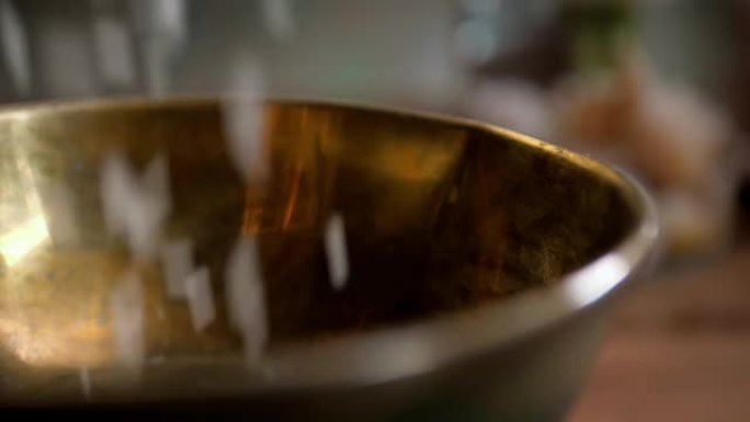 干印度香米落在桌子上的木头金色金属碗里，女人慢动作特写宏观特写