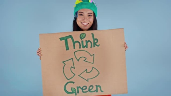 快乐的亚洲女人拿着纸板海报，上面写着绿色