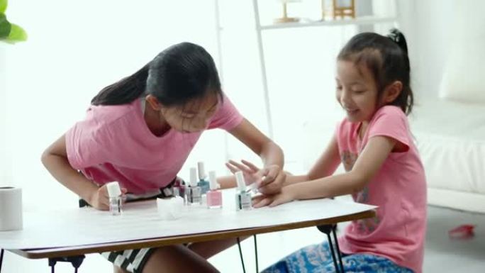 快乐的亚洲儿童画指甲油，同时在家里一起放松，生活方式的概念。