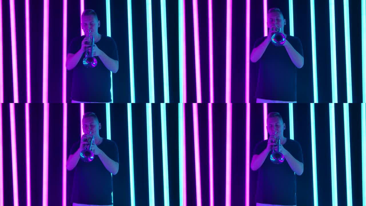 一名男子在工作室里吹小号，背景是粉红色和蓝色的霓虹灯。管道上的经典性能。慢动作。特写