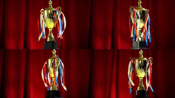 获胜者概念金奖杯放在红色窗帘舞台背景上。