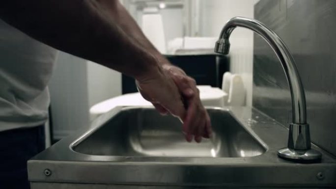 男人用肥皂和清水洗手。我们可以看到那个人在水中一丝不苟地揉着双手。完美的健康预防