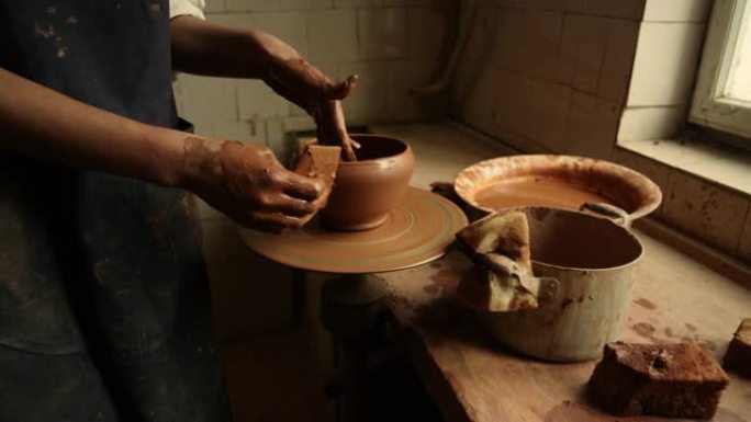 在陶工轮上雕刻的未被认可的艺术家。制作手工锅的女人