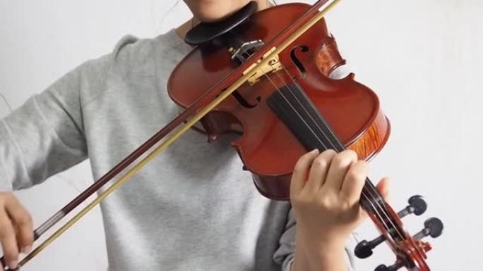女人拉小提琴，展示如何演奏声学乐器