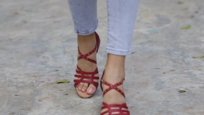 一个女人的脚的特写穿着红色的高跟鞋跳舞。小的脚