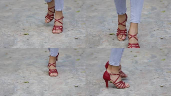 一个女人的脚的特写穿着红色的高跟鞋跳舞。小的脚