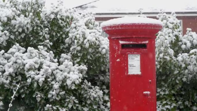 圣诞节飘落的雪中的红色邮筒