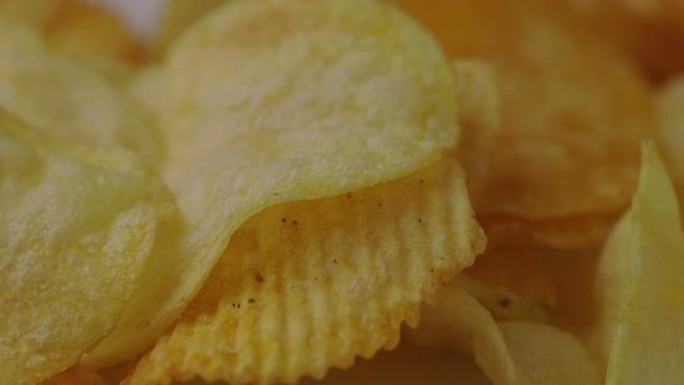 关闭休闲食品脆皮薯片咸旋转缓慢。快餐或垃圾食品零食不健康的概念。