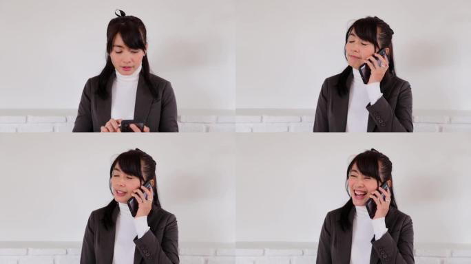 描绘女商人一边站着打电话一边使用手机的情景