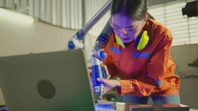 亚洲女工程师专家，带机械臂测量机。三维坐标测量。检查尺寸。零件尺寸的3D检查。加工后的三坐标测量机