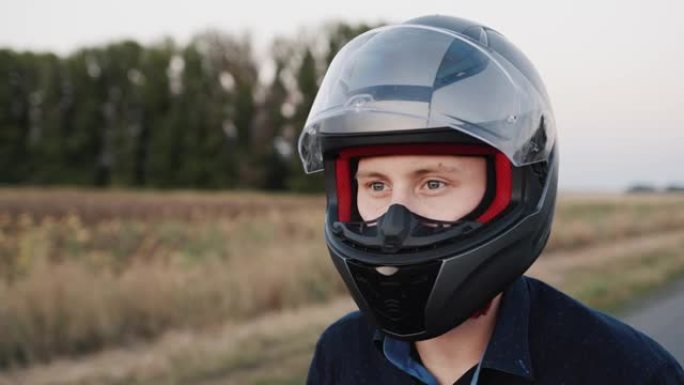 一个年轻骑自行车的人的肖像，准备骑摩托车。关闭头盔上的保护玻璃