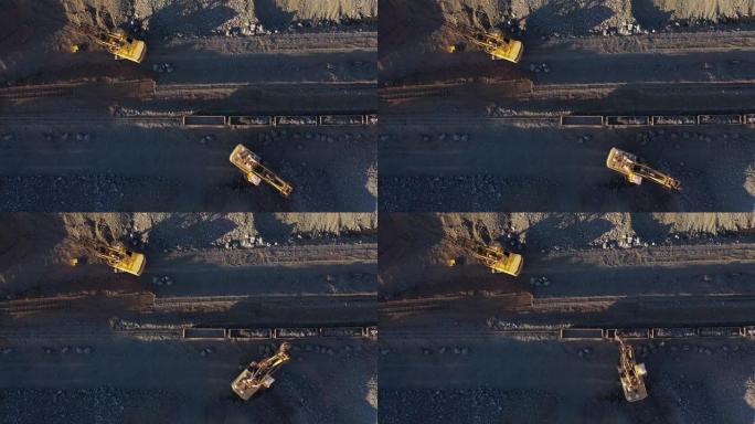 挖掘机将矿石装入货车的空中俯视图。