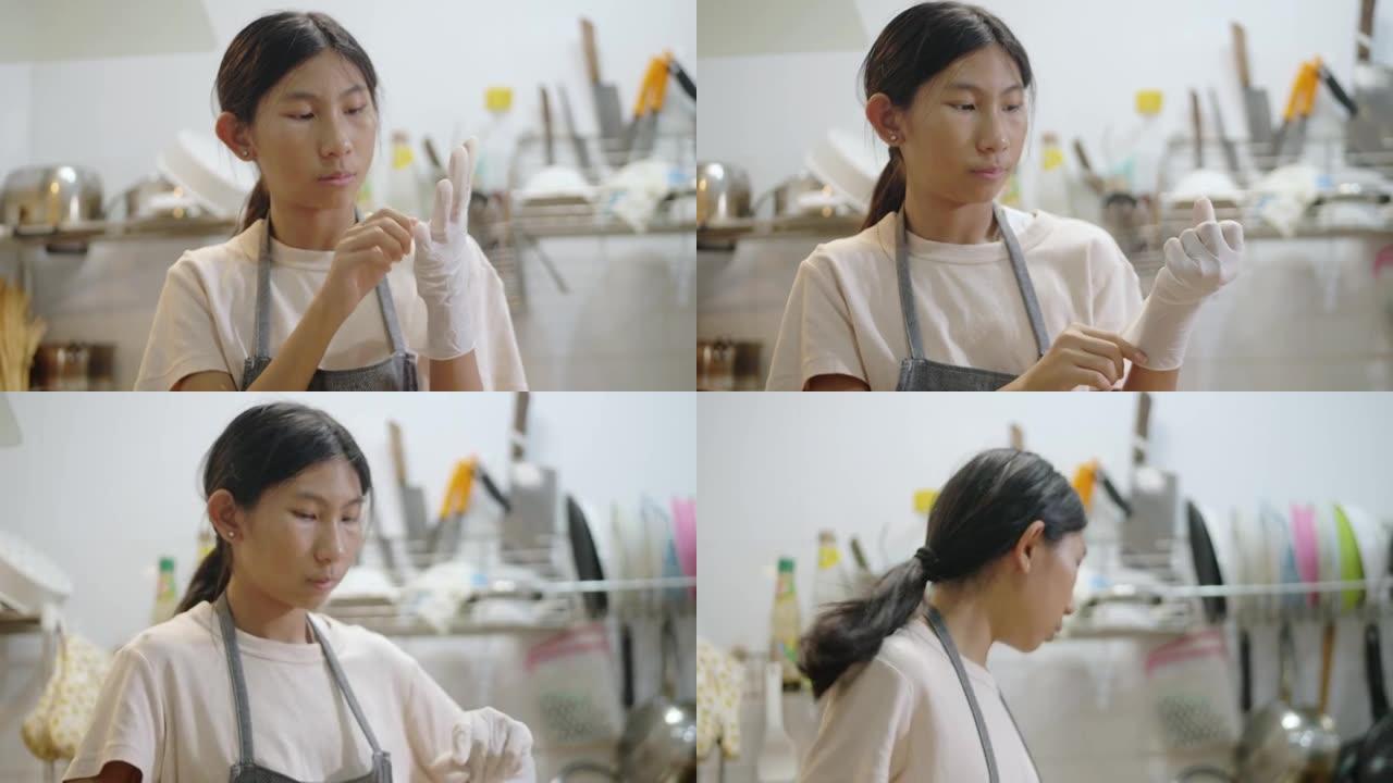 亚洲女孩戴着手手套将爆米花装在塑料袋中，准备食用。