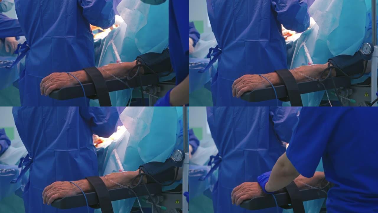 手术过程中患者的手用管子和带子。手术过程与一群医生在手术室。特写。