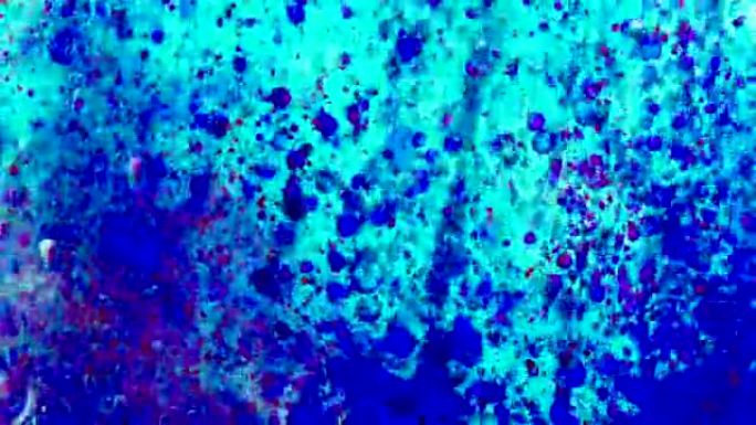 蓝色和红色的油漆滴入油中。4k镜头，微距拍摄，带有墨水和水的抽象背景。气泡漂浮在空间中，并慢慢落下。