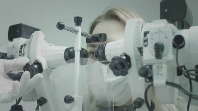 女孩病人在眼科医生的办公室检查视力。治愈眼睛，恢复视力。一种用于检查视力的医疗设备。医生负责病人的眼