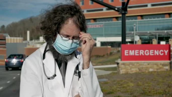 心烦意乱的男医生在医院外戴着口罩自言自语