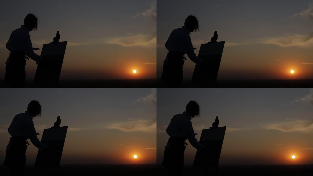 一个在日落时画画的女孩的剪影