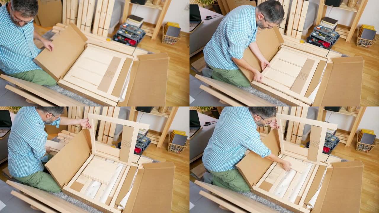 中年男子在家中打开装有新家具的纸板箱