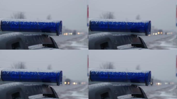 傍晚，警车的蓝色灯光在雪地上闪烁。特写镜头
