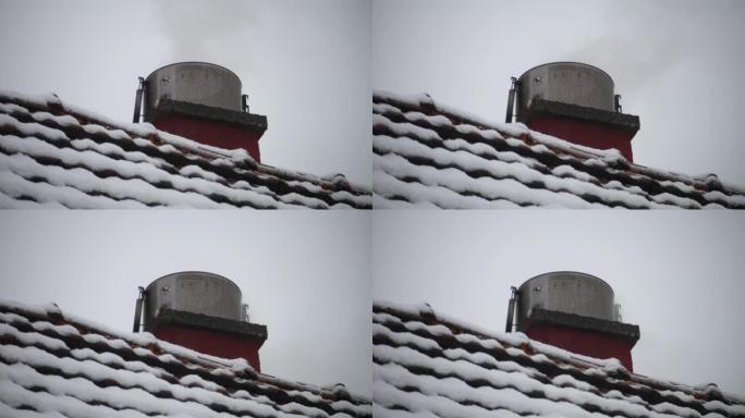 雪下烟囱和屋顶冒出灰烟