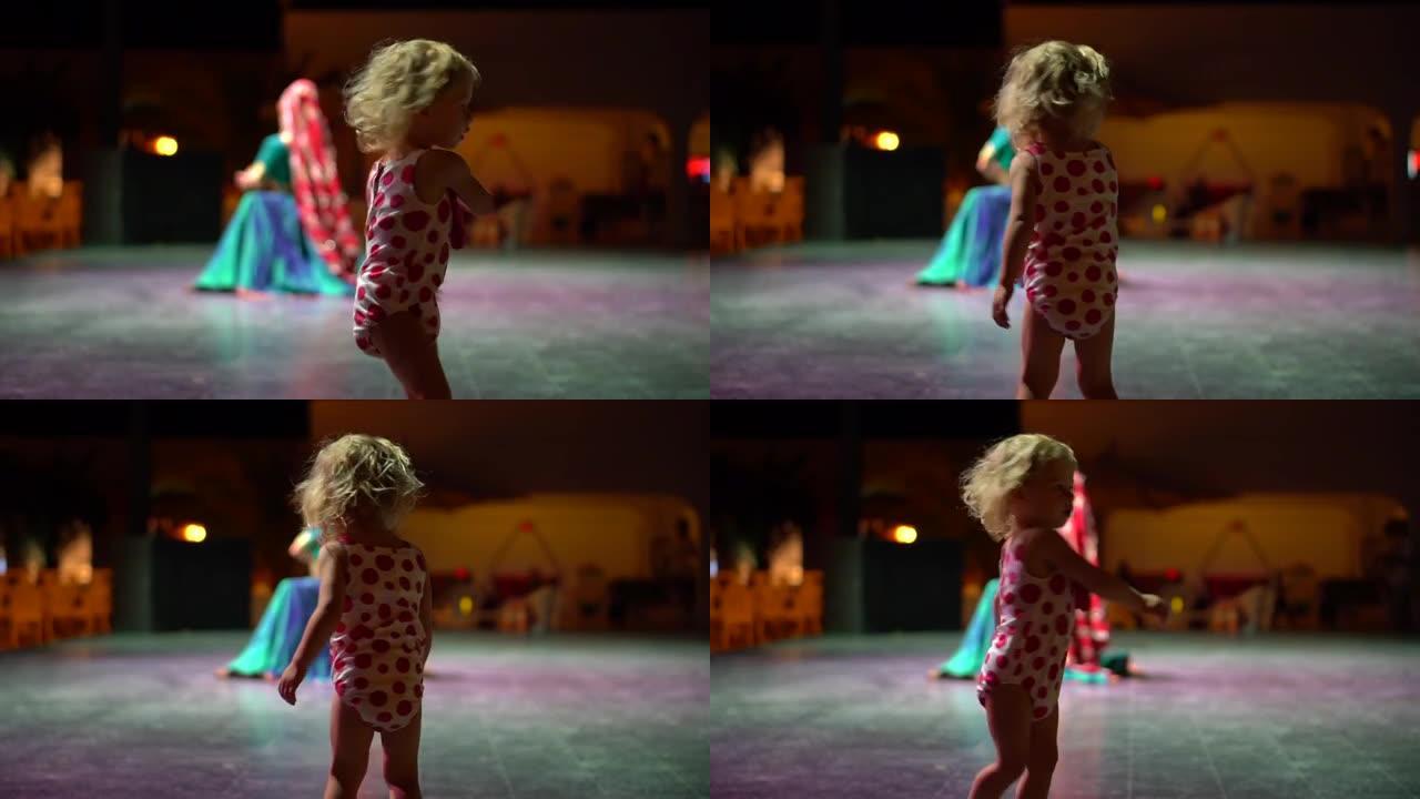 迷你迪斯科。酒店为儿童提供晚间娱乐。这孩子正在晚上的迪斯科舞厅跳舞。女孩在灯光和音乐下旋转。