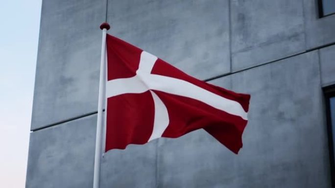 丹麦国旗在灰色建筑外吹拂