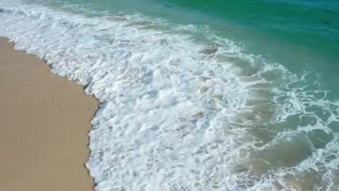 海浪在巴厘岛的白色沙滩上破裂