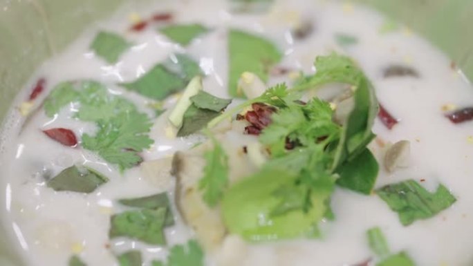 SLO MO: 在绿色陶瓷碗中放入泰国椰奶汤和鸡肉和蘑菇的特写镜头。