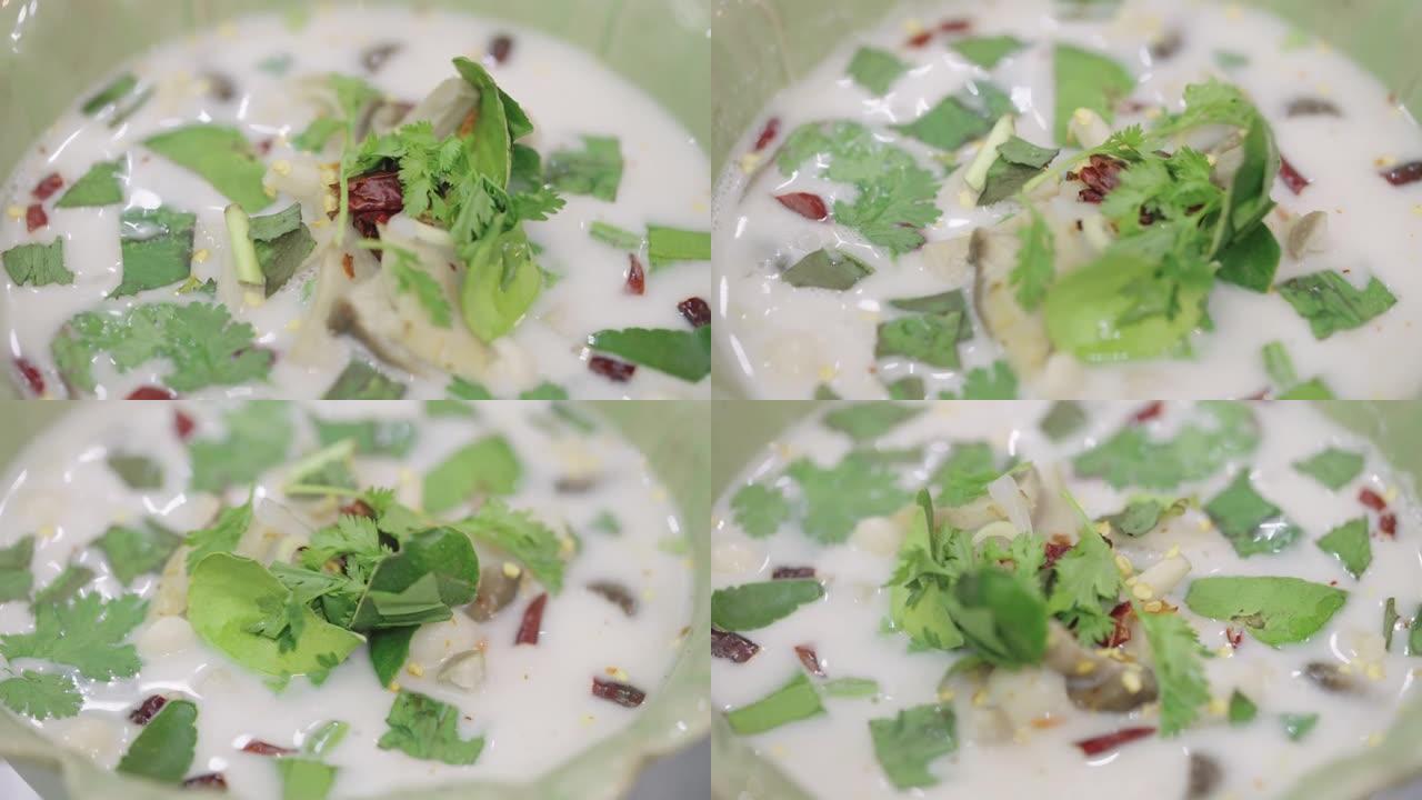 SLO MO: 在绿色陶瓷碗中放入泰国椰奶汤和鸡肉和蘑菇的特写镜头。