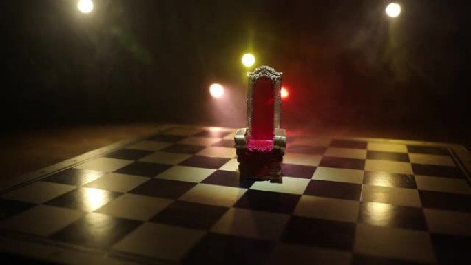 木制桌子上的红色皇家椅子微型。棋盘上的中世纪宝座。棋盘游戏的经营理念和竞争战略理念。选择性聚焦
