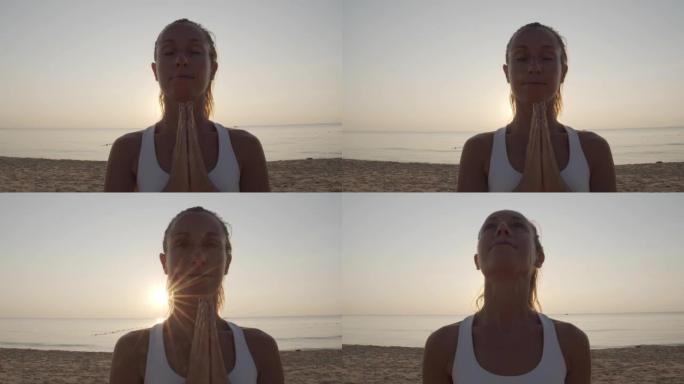 封闭起来，年轻女子在日落时冥想祈祷。日落时在海滩上练习瑜伽的女性姿势
