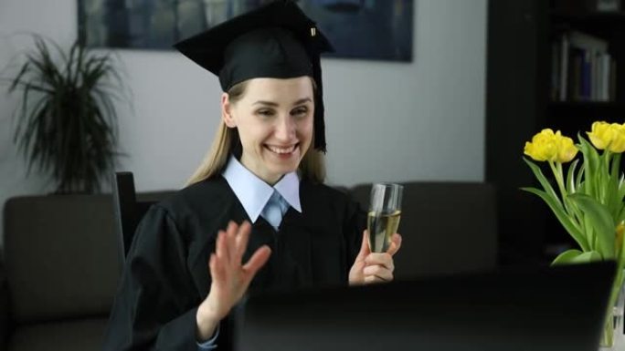 社交距离毕业派对-女性毕业生穿着礼服，在家与大学朋友在线庆祝学士学位