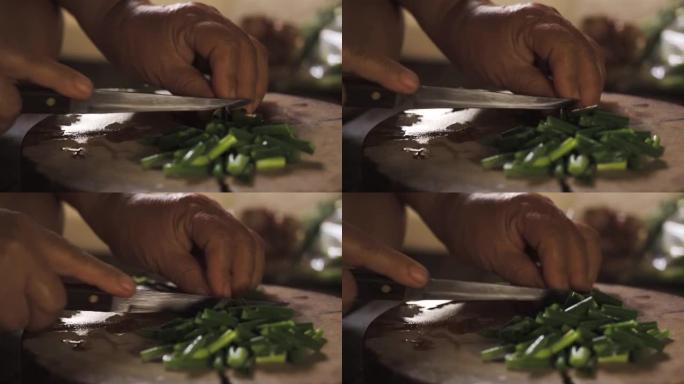 大葱被老太太用烹饪刀切碎。准备烹饪健康菜单。