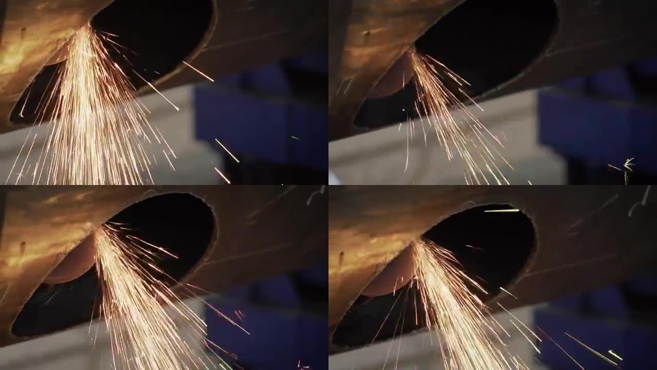 重工业工人切割一根巨大的管子。工作磨床在工厂切割金属。