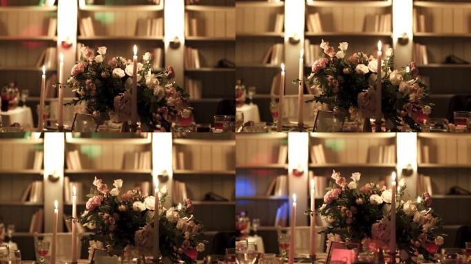鲜花和蜡烛立在节日的桌子上。蜡烛发出的光照亮了房间