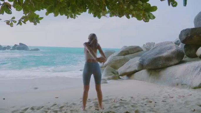 瑜伽姿势的女人美女沙滩岩石锻炼身体做操