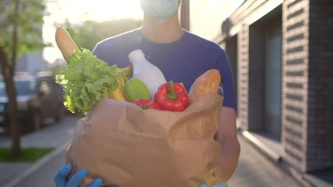 送货员在城市街道户外之家拿着带食物的纸袋