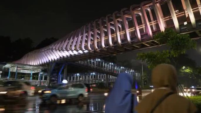 雨夜雅加达市市中心照明交通街著名现代人行天桥全景4k印度尼西亚