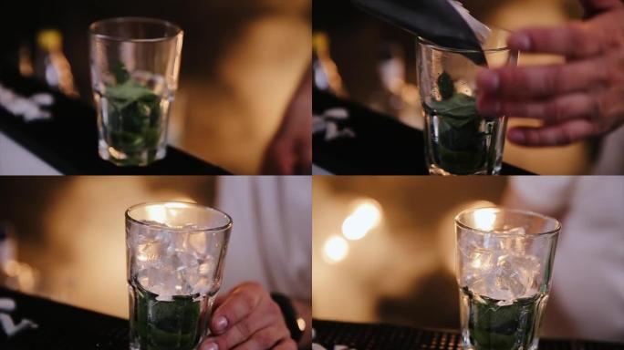 调酒师正在准备酒精鸡尾酒莫吉托时，将专业的水晶冰块放入玻璃杯中。特写