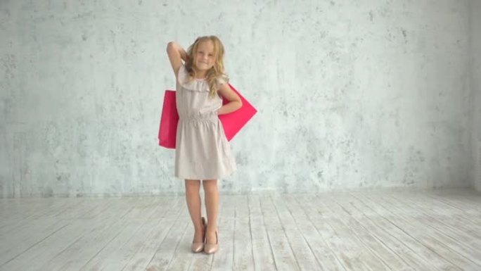 家庭购物，包，购物女孩。有趣的儿童小女孩时尚达人穿着大妈妈的鞋子，穿着购物袋。穿着大鞋的女孩手里拿着