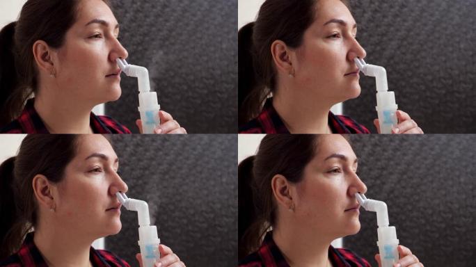 一名妇女使用雾化器吸入鼻腔蒸汽的特写镜头
