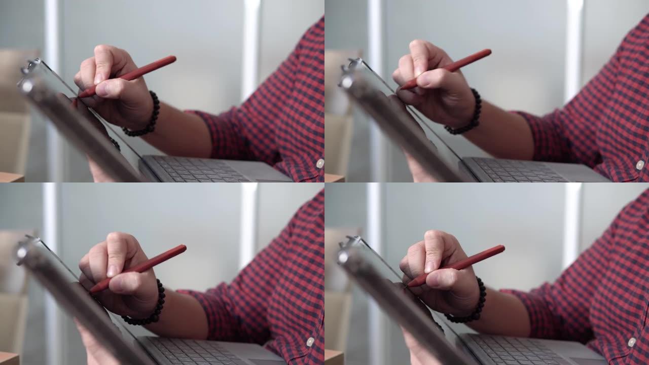 亚洲人在数字平板电脑显示屏上使用数字笔书写笔记。